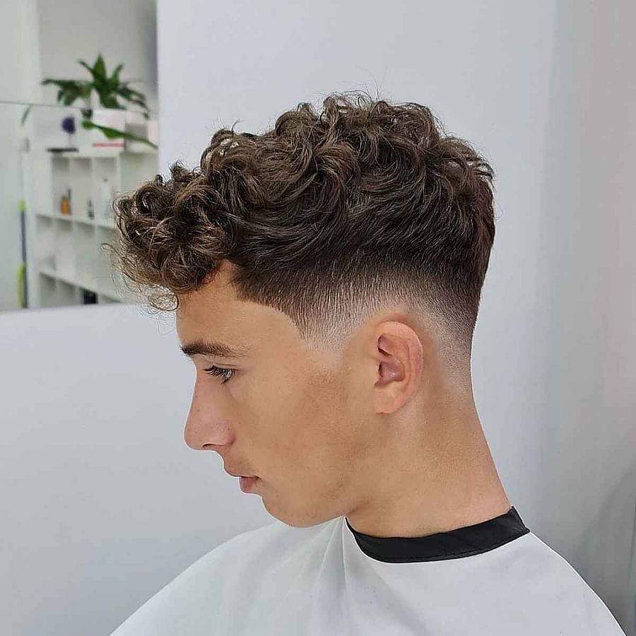Stylish man with low fade curly hairstyle
